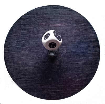 Maalatulla puupohjalla veistetty sormi, jonka päällä arpakuutio, jossa tähtiä.